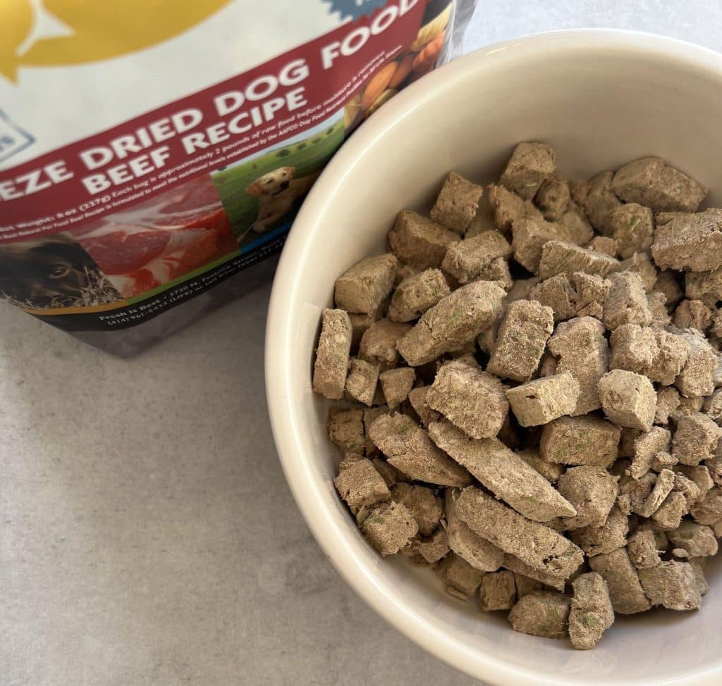 Bowl of Fresh Is Best freeze-dried beef dog food beside its product packaging.